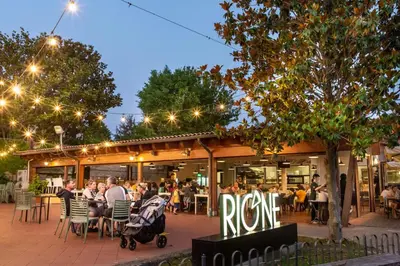 a group of people sitting at tables outside of a restaurant at hu Roma Camping In Town in Rome