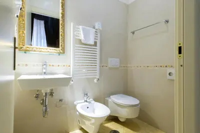 a bathroom with a sink and a toilet and a mirror at DCBoutiqueHotel in Rome