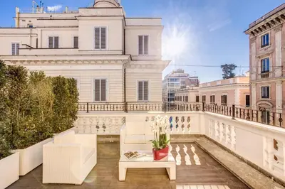 a balcony with white furniture and a white building at The Liberty Boutique Hotel in Rome