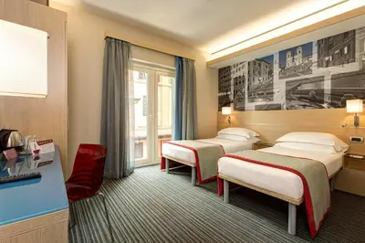 a hotel room with two beds and a window at iQ Hotel Roma in Rome