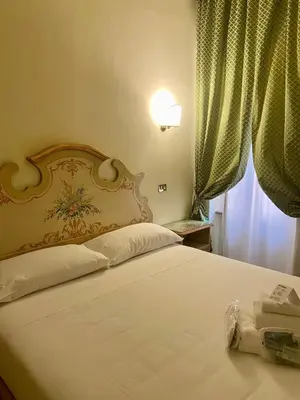 a bedroom with a white bed with a window at Sourire Hotel in Rome
