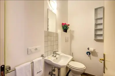 a white bathroom with a sink and a toilet at Cuore di Florio Apartment in Rome