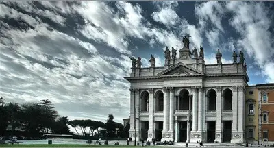 a large white building with a cloudy sky at T C RMs in Rome