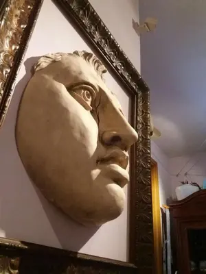 a bust of a man in a frame on a wall at Priscilla's inn in Rome
