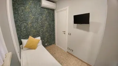 a small room with a couch and a tv on a wall at Vatican69 New Apartment in Rome