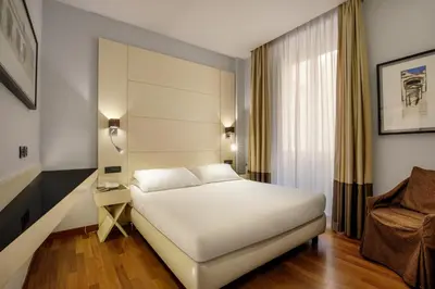 a hotel room with a white bed and a window at Hotel Oxford in Rome