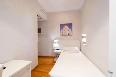 a small room with a bed and a desk at Hotel Oxford in Rome