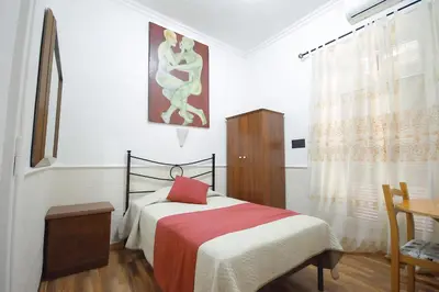 a bedroom with a bed with a red pillow on it at Hotel Alexis in Rome