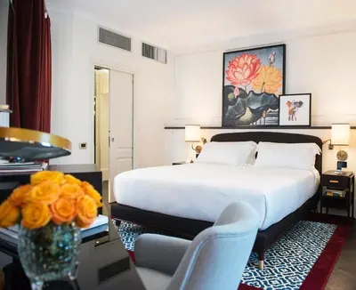 a hotel room with a bed and a table and chairs at Hotel Vilòn - Small Luxury Hotels of the World in Rome
