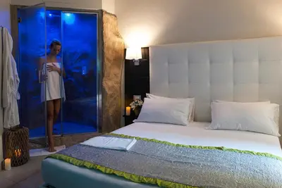 a woman standing in a shower next to a bed at Roman Holidays Boutique Hotel in Rome
