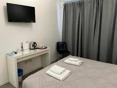 a room with a bed with a desk and a television on the wall at Rome Vatican Rooms in Rome
