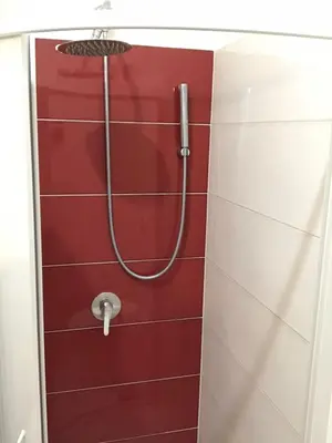 a shower in a red and white tiled bathroom at Ann Inn in Rome
