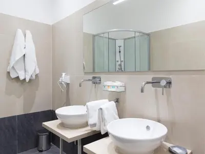 a bathroom with a sink and a mirror at Venustas Roma Hotel in Rome