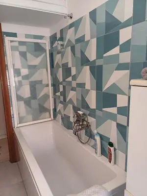 a bath tub in a bathroom with a tiled wall at Double room da Giulio in Rome