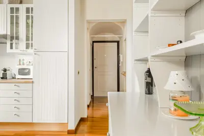 a kitchen with white cabinets and a white counter top at Navona Bernini Lodge in Rome