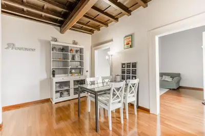 a dining room with a glass table and white chairs at Navona Bernini Lodge in Rome
