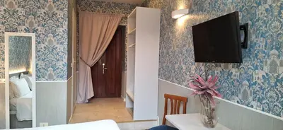 a dining room with blue wallpaper and a tv on the wall at Welcome House in Rome