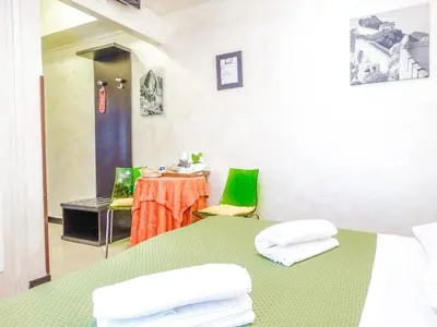 a room with a green table and a table and chairs at B&B Morelli 1 in Rome