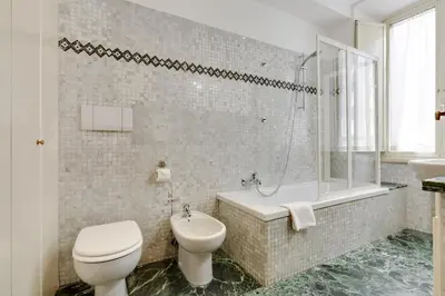 a bathroom with a toilet and a tub and a sink at Rome as you feel - Panisperna Apartment in Rome