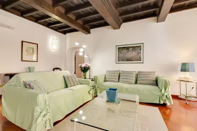a living room with two green couches and a table at Rome as you feel - Panisperna Apartment in Rome