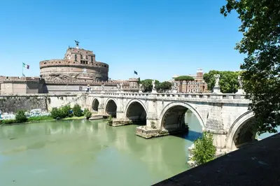 a bridge over a river in front of a building at Piazza Cavour Suite in Rome