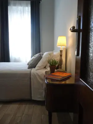 a bedroom with a bed and a table with a lamp at Le Volute al Pigneto in Rome