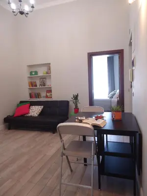 a living room with a table and chairs and a couch at Le Volute al Pigneto in Rome