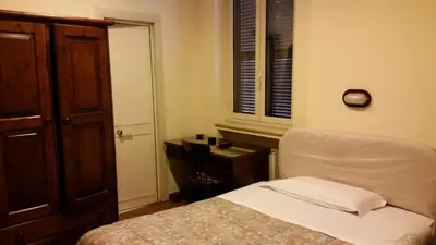 a bedroom with a bed and a chair and a desk at Hotel Croce Di Malta in Rome
