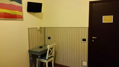 a room with a desk and a table and a door at Hotel Croce Di Malta in Rome