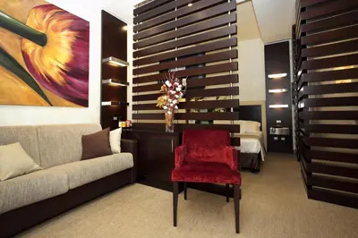 a living room with a couch and a red chair at Les Fleurs Luxury House in Rome