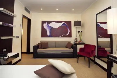 a living room with a couch and a red chair at Les Fleurs Luxury House in Rome