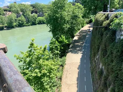 a road next to a river next to a wall at Palazzo Baj in Trastevere in Rome