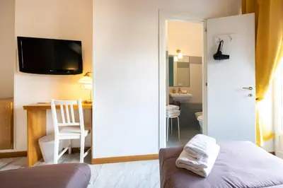 a room with a bed and a desk and a television at Aurelia Home Guest House in Rome