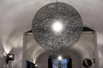 a large orb light fixture hanging from a ceiling at Casa de' Coronari Suites in Rome