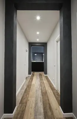 an empty hallway with black and white walls and wood floors at Ara Suite in Rome