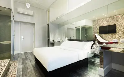 a bedroom with a large white bed and a glass wall at LE RÊVE DE NAIM Roma in Rome