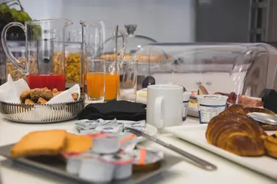 a table topped with plates of food and orange juice at Mascherino Suites in Rome