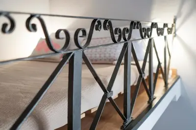 a black metal bed frame in a bedroom at Frankie Charme in Rome
