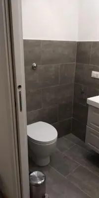 a bathroom with a toilet and a tiled floor at Frankie Charme in Rome