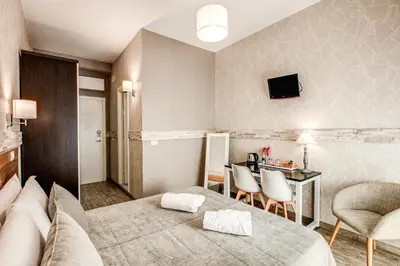 a hotel room with a bed and a table and chairs at Santamaria Inn in Rome