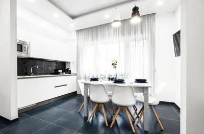 a kitchen with a white table and chairs at Ma Belle Maison in Rome