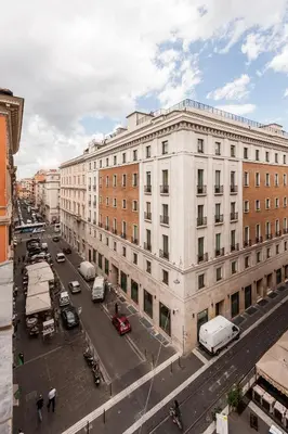 a large white building on a city street with cars at Hotel California in Rome