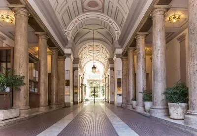 an empty lobby with columns and a ceiling at Nazionale Palace Suites in Rome
