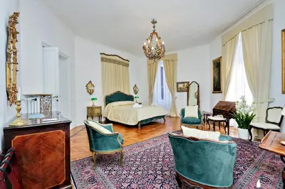 a large living room with a bed and chairs at Prestigious Apartment Via Veneto in Rome