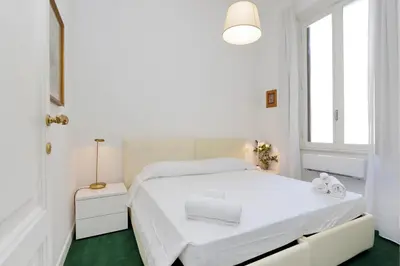 a white bedroom with a white bed and a window at Prestigious Apartment Via Veneto in Rome