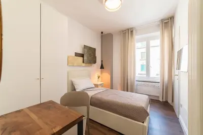 a small bedroom with a bed and a table at Guest Roma House in Rome