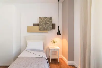 a small bedroom with a bed and a side table at Guest Roma House in Rome