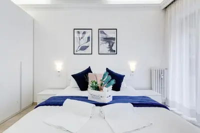 a white bedroom with a large bed with blue sheets at DIDAVI' Guest House in Rome