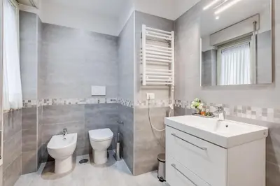 a white bathroom with a toilet and a sink at DIDAVI' Guest House in Rome
