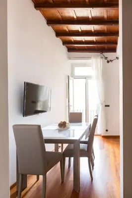 a dining room with a table and chairs and a tv at The Hide Trastevere in Rome